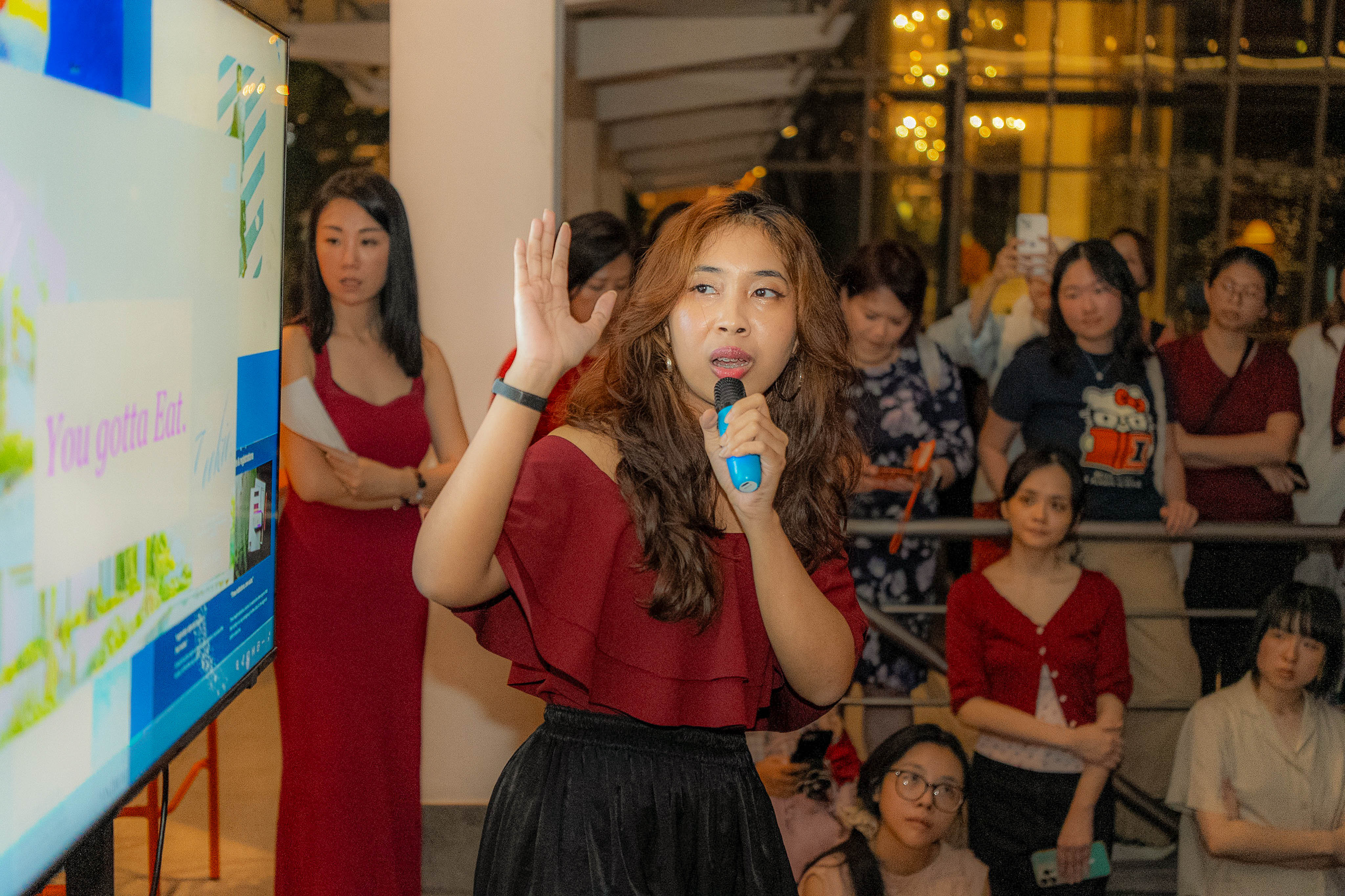 Aya presenting beside her slide, hand raised