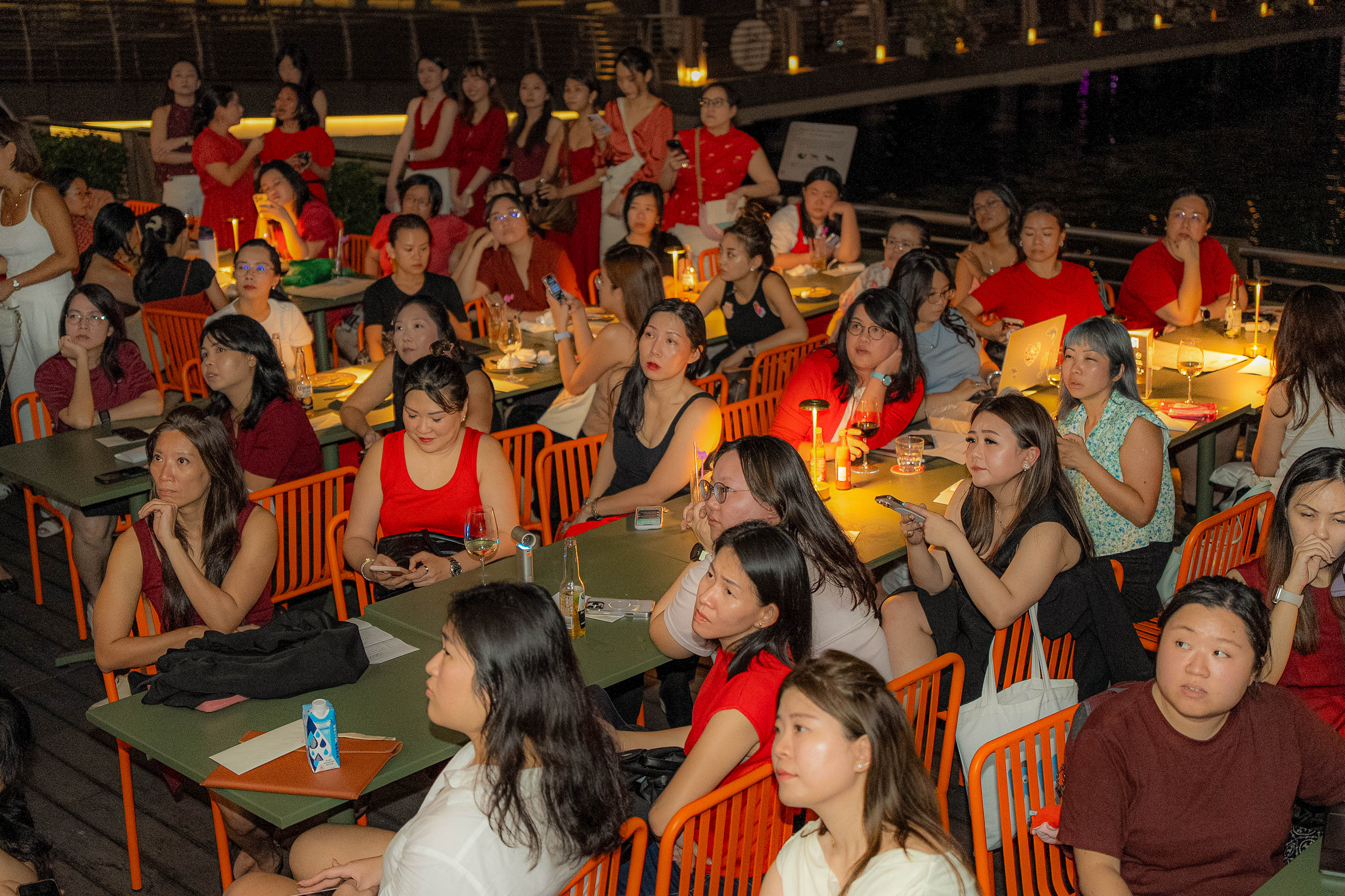 Participants at dinner tables watching Aya's presentation