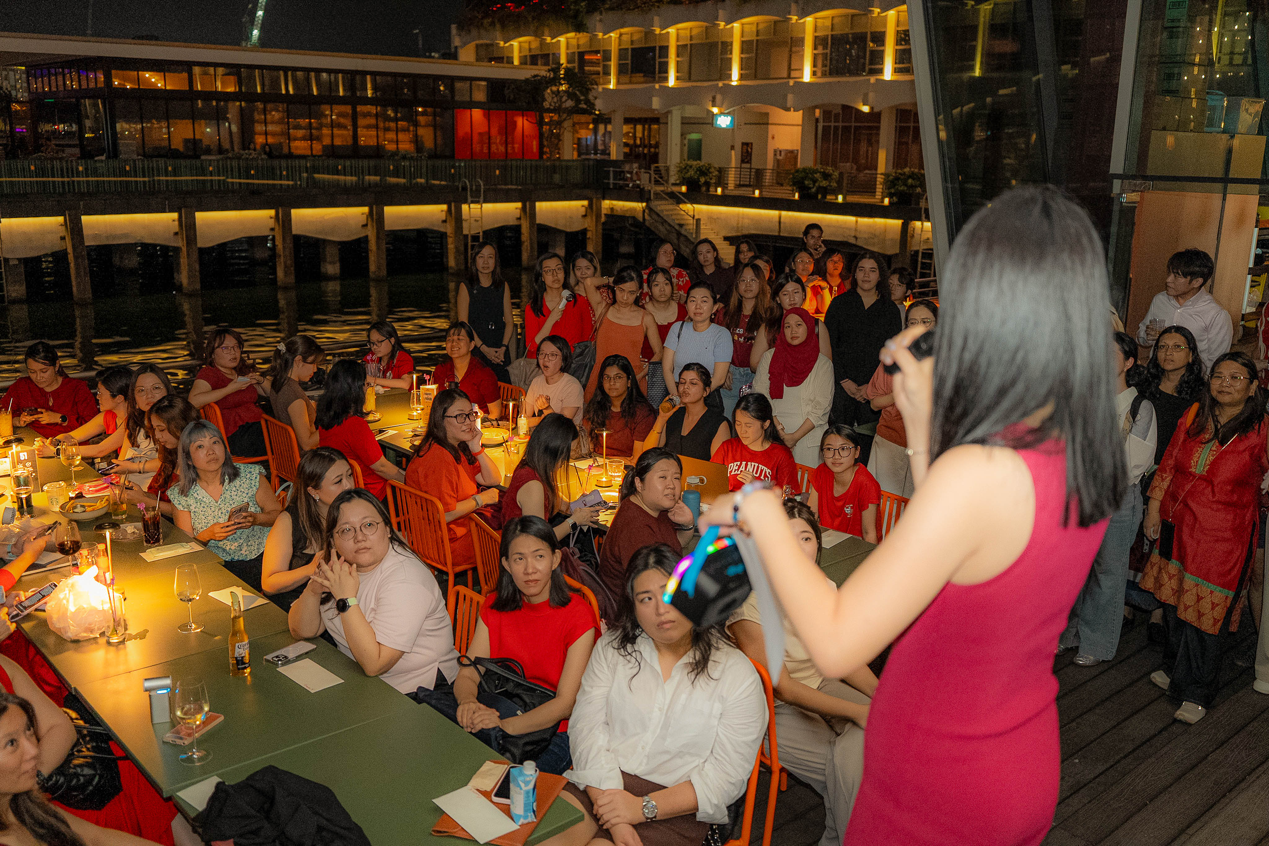 The full house listening in, tables lit by candle lamps