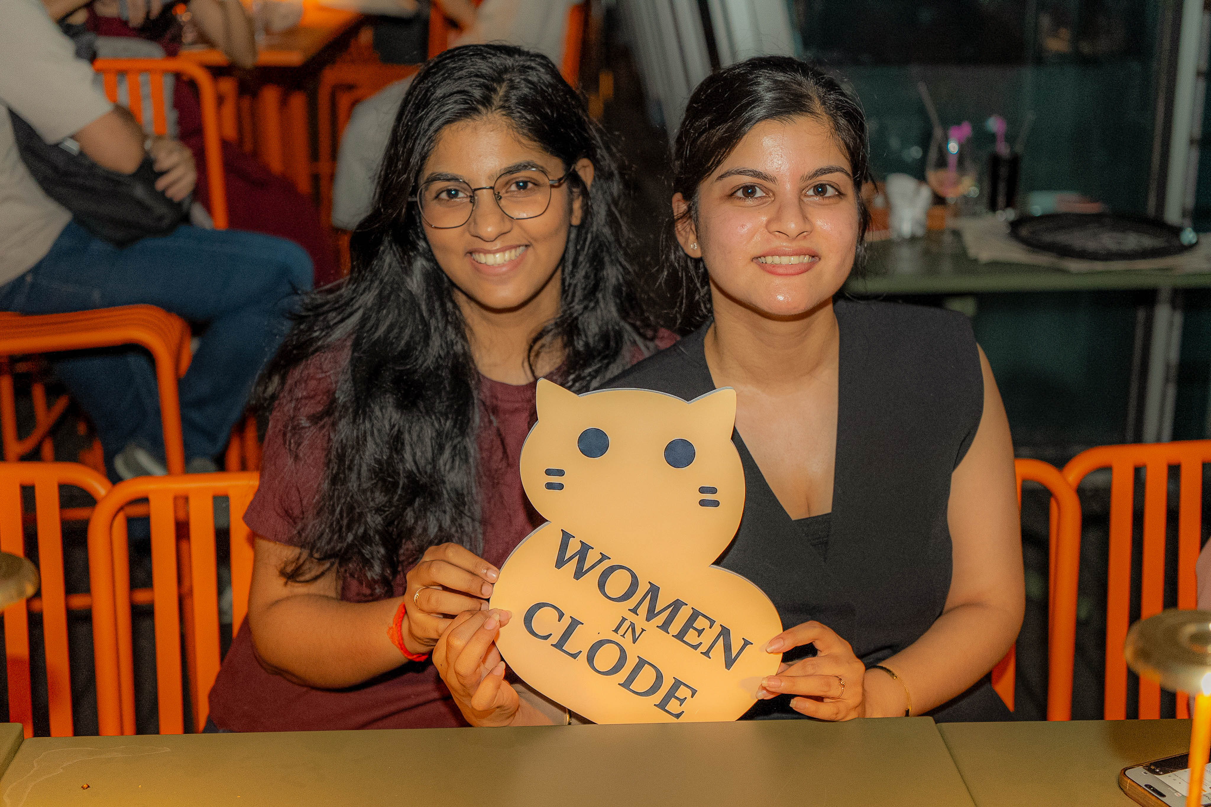 Two Clodettes holding the Women in Clode cat sign