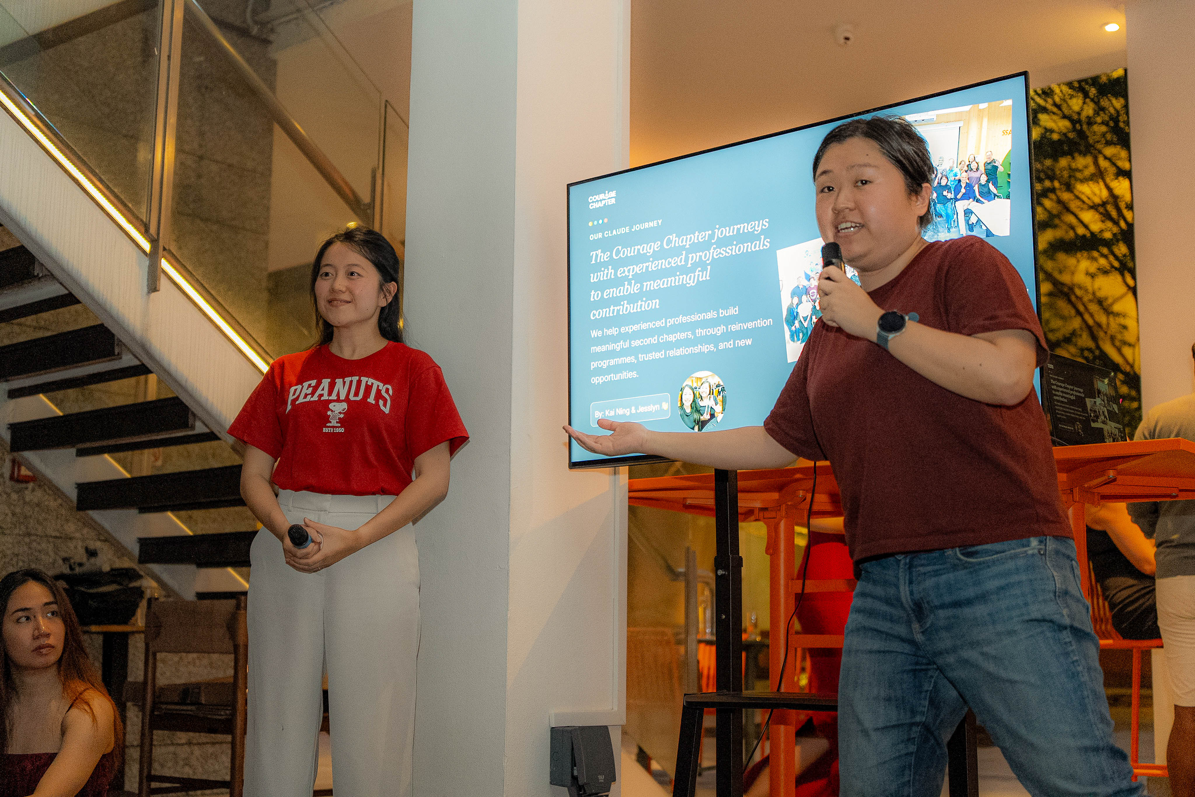 Kai Ning and Jesslyn presenting beside the Our Claude Journey slide