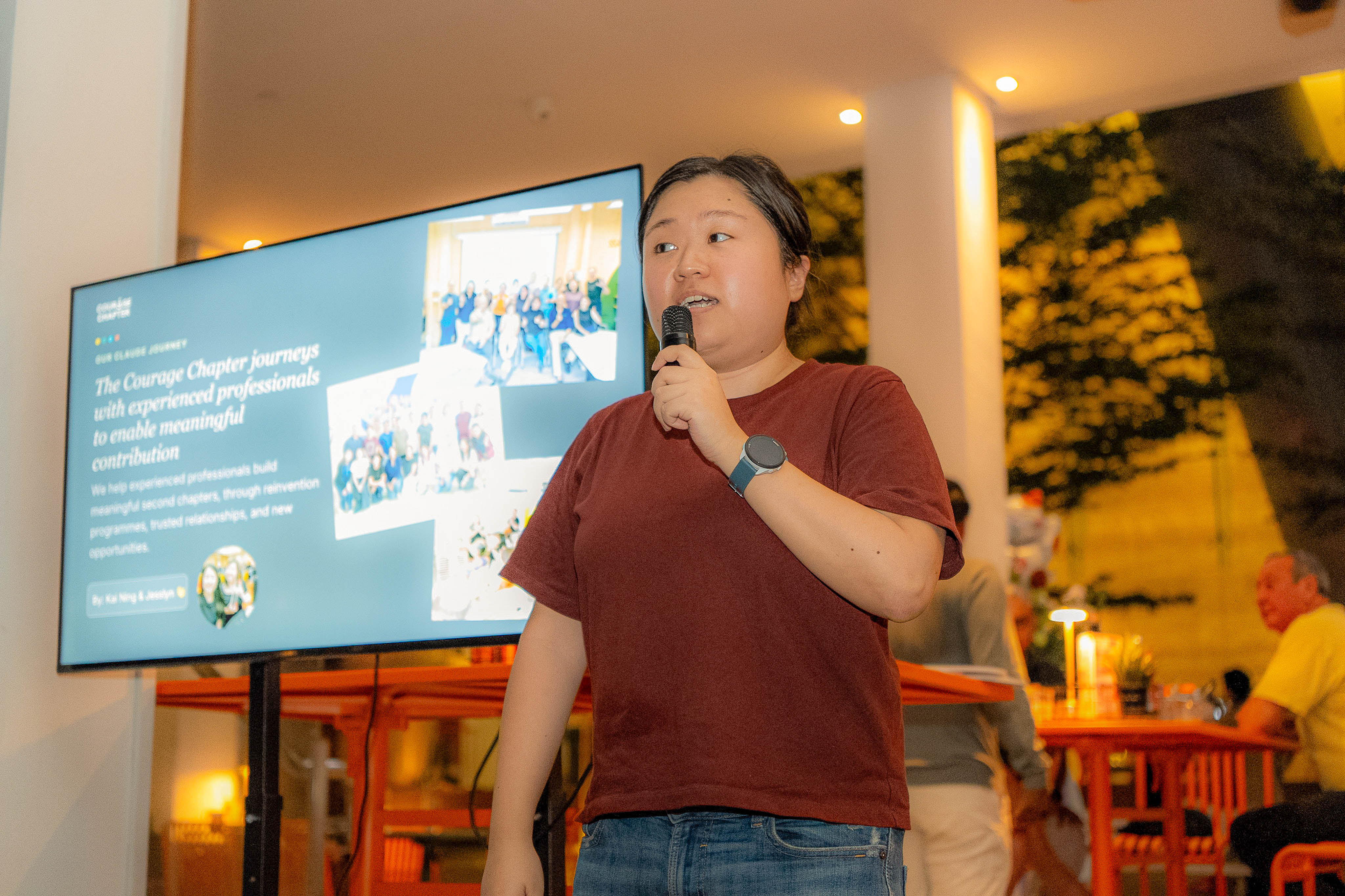 Kai Ning speaking into the mic with the presentation slide behind